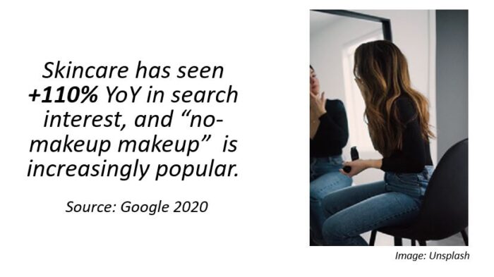 girl in mirror putting on makeup